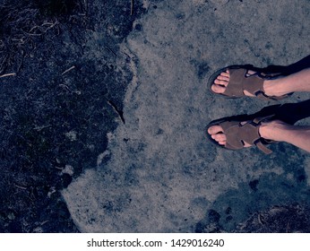 Male Hairy Legs With Sandals Rest On Rocky Summit Above Valley Of Natural Park. Lazy Sunny Summer Day.