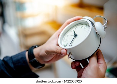 Male hand adjusting or changing the time on white clock. Time management concept. - Shutterstock ID 1422003920