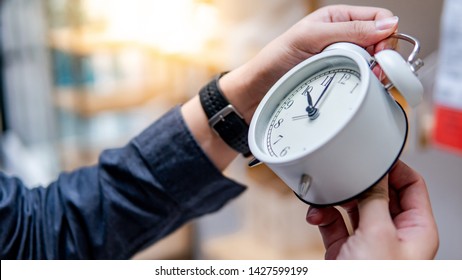 Male Hand Adjusting Or Changing The Time On White Clock. Time Management Concept.