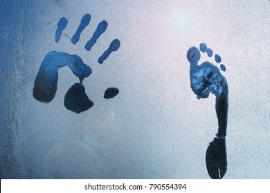 Male Hand Ang Foot Print On Frozen Windows Glass