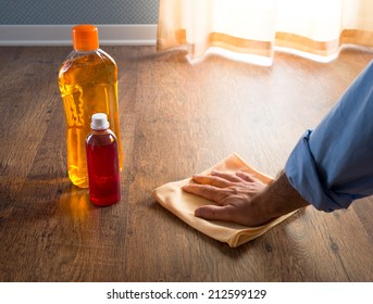 Male Hand Applying Wood Care Products On Hardwood Floor Surface With A Microfiber Cloth.