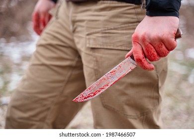 Male Hand With Bloody Knife Outdoor.