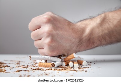 Male hand breaking a cigarettes. Quitting smoking