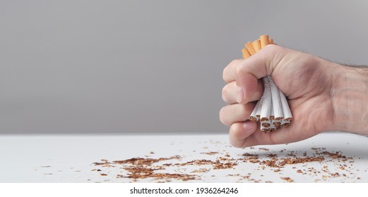Male hand breaking a cigarettes. Quitting smoking