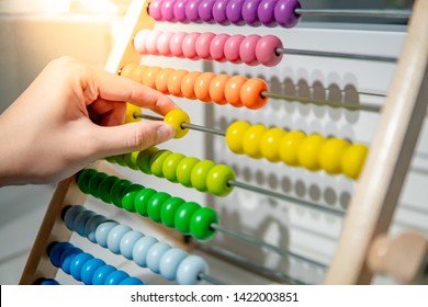 Male hand calculating with beads on wooden rainbow abacus for number calculation. Mathematics learning concept - Powered by Shutterstock