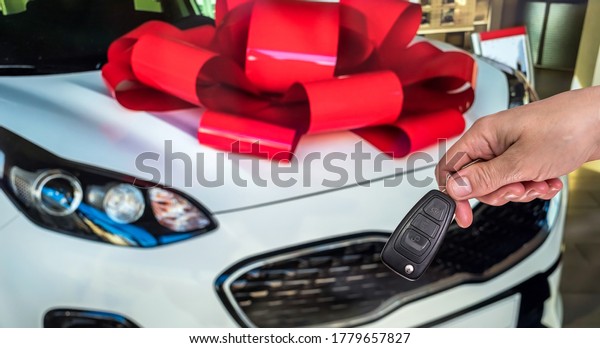 Male hand with car keys with auto on background.\
Rent or purchase