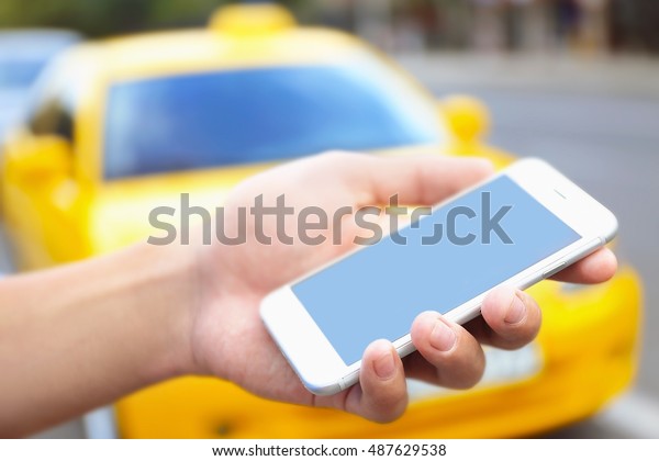 Male hand with cellphone\
calling taxi