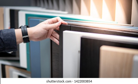 Male hand choosing cabinet panel materials or countertops for built-in furniture design. Shopping furniture and decoration. Home improvement concept - Shutterstock ID 1422003854