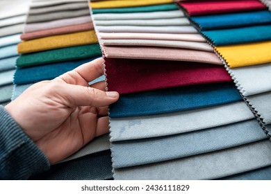 Male hand choosing perfect colorful fabric samples for new sofa and chairs in new home. Flat lay, fabrics of different colors - Powered by Shutterstock