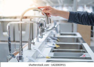 Male Hand Choosing Stainless Steel Water Tap In Furniture Store. Home Improvement For Domestic Kitchen.