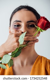 Male Hand Covering Mouth To Indian Woman With Bruise While Holding Rose Isolated On Grey