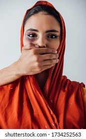 Male Hand Covering Mouth To Indian Woman With Bruise Isolated On Grey