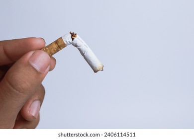 Male hand crushing a cigarette, Quit smoking concept, World No Tobacco Day