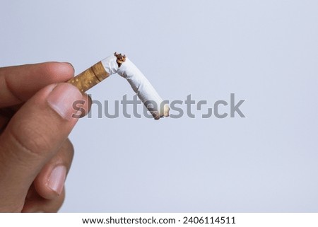 Male hand crushing a cigarette, Quit smoking concept, World No Tobacco Day