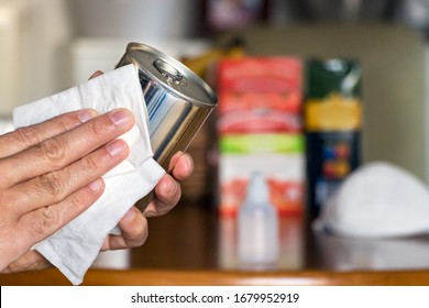 Male hand desinfecting a canned food at home, after grocery shopping. - Shutterstock ID 1679952919