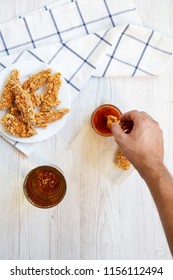 Male Hand Dipping Chicken Fingers Into Sauce, Overhead View. Top View, From Above.