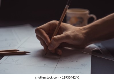 male hand drawing storyboard conceptual ideas with coffee cup in the background, hard work sketching art concept