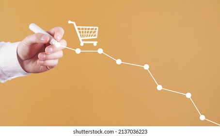 Male Hand Draws Down Graph With A Shopping Cart. Sales Decline