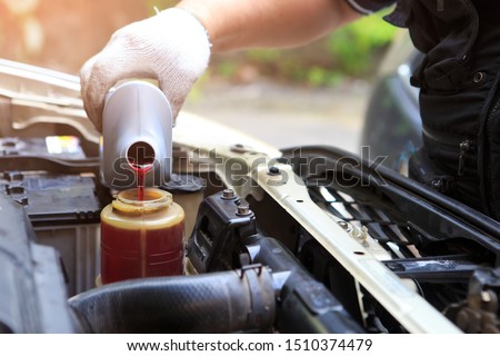 Male hand filling car power steering fluid