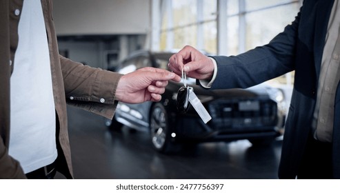 Male hand gives a car keys to male hand in the car dealership close up. Unrecognized auto seller and a man who bought a vehicle shake hands. - Powered by Shutterstock