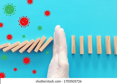 A Male Hand In Glove Stopping The Domino Effect. Covid 19 Or Coronavirus Blocking Concept