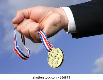 male  hand with gold medal