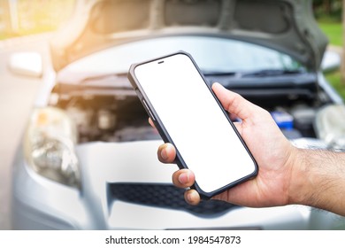 male hand holding a black smartphone with a white touch screen Call an insurance company or a mechanic for help. Because he had an accident or the car engine broke down. car insurance