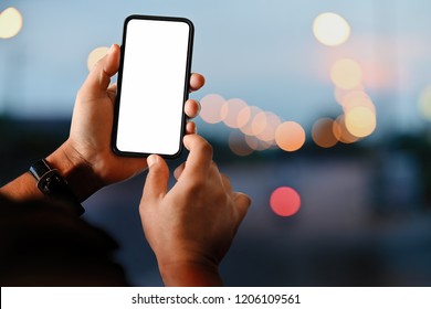 Male Hand Holding Blank Screen Mobile Smart Phone At Street Night.