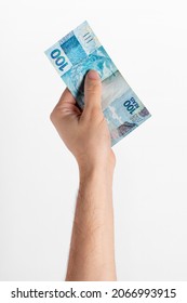 Male hand holding brazilian money