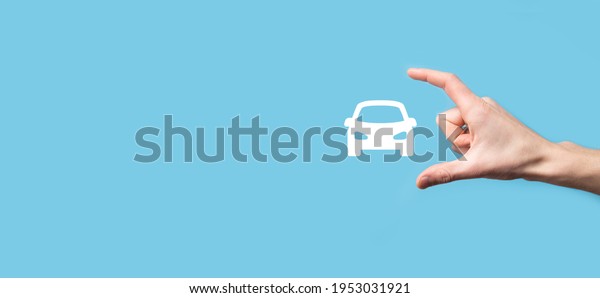 Male hand holding car auto icon on blue\
background. Wide banner composition.Car automobile insurance and\
collision damage waiver\
concepts.