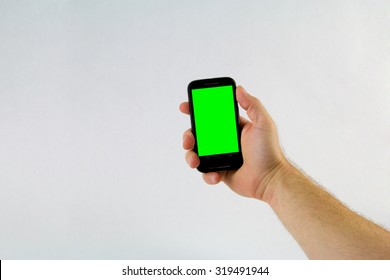 Male Hand Holding Cell Phone On White Background With Green Screen