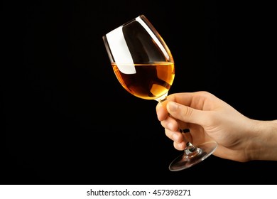 Male Hand Holding Glass Of Wine On Black Background