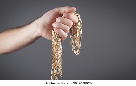 Male Hand Holding Gold Jewelry. 