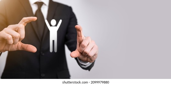 Male Hand Holding Human Icon On Grey Background. Human Resources HR Management Recruitment Employment Headhunting Concept.Select Team Leader Concept. Male Hand Click On Man Icon.Banner ,copy Spase