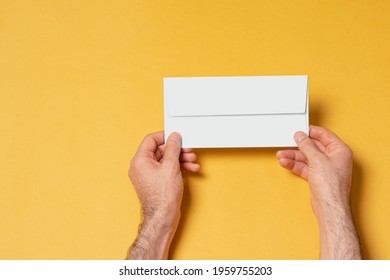 Male Hand Holding A Letterhead Paper Envelope, Editable PSD Mock Up Template With Smart Object Layers For Your Design, Selection Path Included.