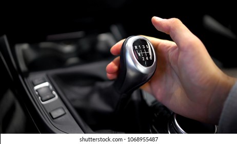Male hand holding manual gearbox in car, test drive of new automobile, closeup - Shutterstock ID 1068955487