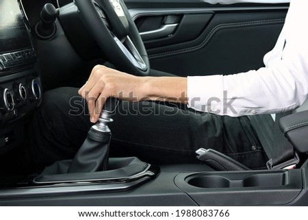 Male hand holding manual gearbox of car