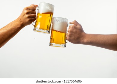 Male Hand Holding Mug Of Beer Light Background. Beer Toast On White Background.