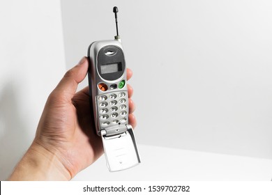 Male Hand Holding Old Cell Phone Isolated On White Background.