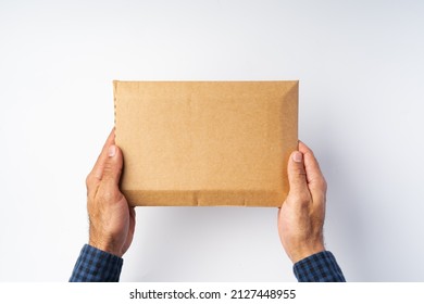 Male Hand Holding Parcel Post Against White Background, Close Up