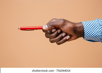 Male Hand Holding Pencil, Isolated On Studio Brown Background