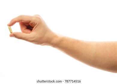 Male Hand Holding A Pill Against White Background. Medicine. Close-up Man Hand Holding Medication, Medical Capsule. Health Care, Cure Concept. Alpha