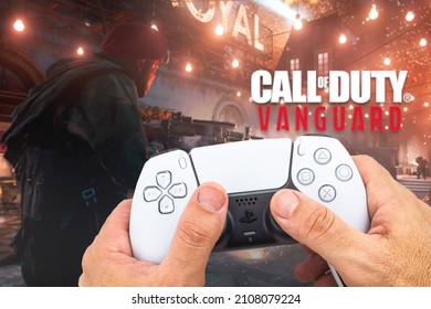 Male hand holding a Playstation 5 Dual Sense Controller with Call of Duty Vanguard game blurred in the background. Rio de Janeiro, RJ, Brazil. October 2021.