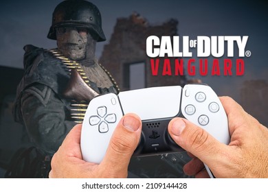 Male hand holding a Playstation 5 Dual Sense Controller with Call of Duty Vanguard game blurred in the background. Rio de Janeiro, RJ, Brazil. October 2021.