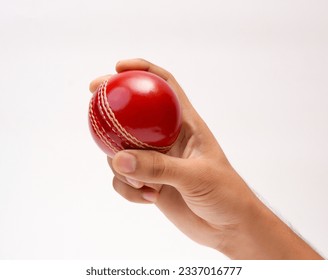 A Male Hand Holding A Red Test Match Leather Stitch Cricket Ball Closeup Picture White Background - Powered by Shutterstock