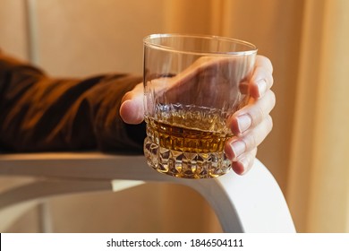 Male Hand Holding A Shot Of Whiskey. Close-up Shot Of The Glass With Bourbon, Scotch Or Brandy