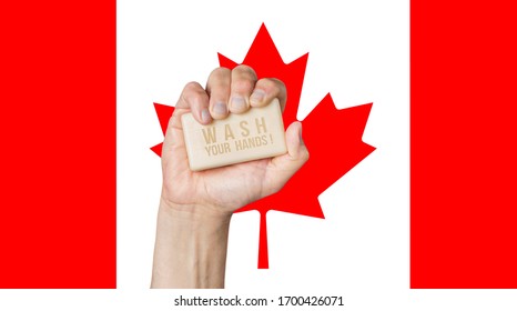 Male Hand Holding Soap With Words: Wash Your Hands, Against A Canadian Flag