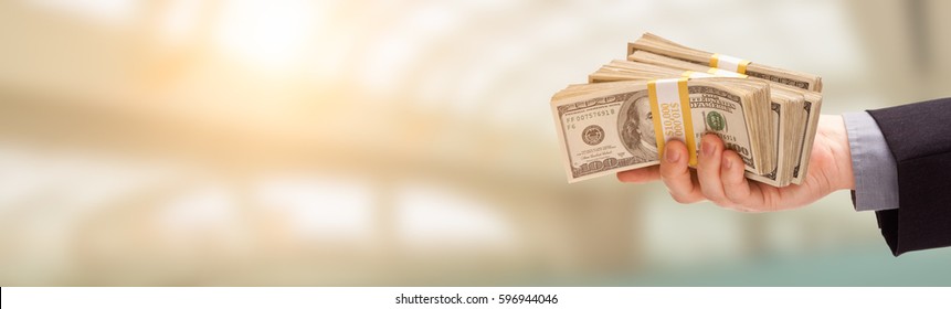 Male Hand Holding Stack of Cash Wide Banner With Room For Copy. - Shutterstock ID 596944046