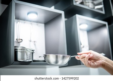 Male Hand Holding Stainless Steel Cooking Pan In Cookware Store Showroom. Buying New Kitchenware Concept