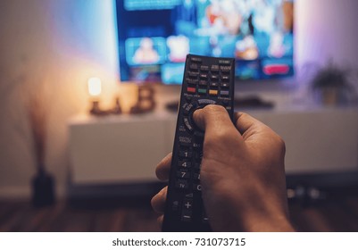 Male Hand Holding TV Remote Control. Point Of View Shot